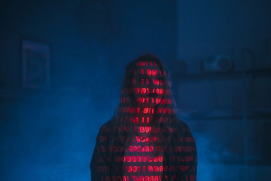 A close-up view of a computer screen displaying lines of HTML code in colorful syntax highlighting, including tags such as <h1>, <div>, and <img> with attributes like alt and class. The code features 